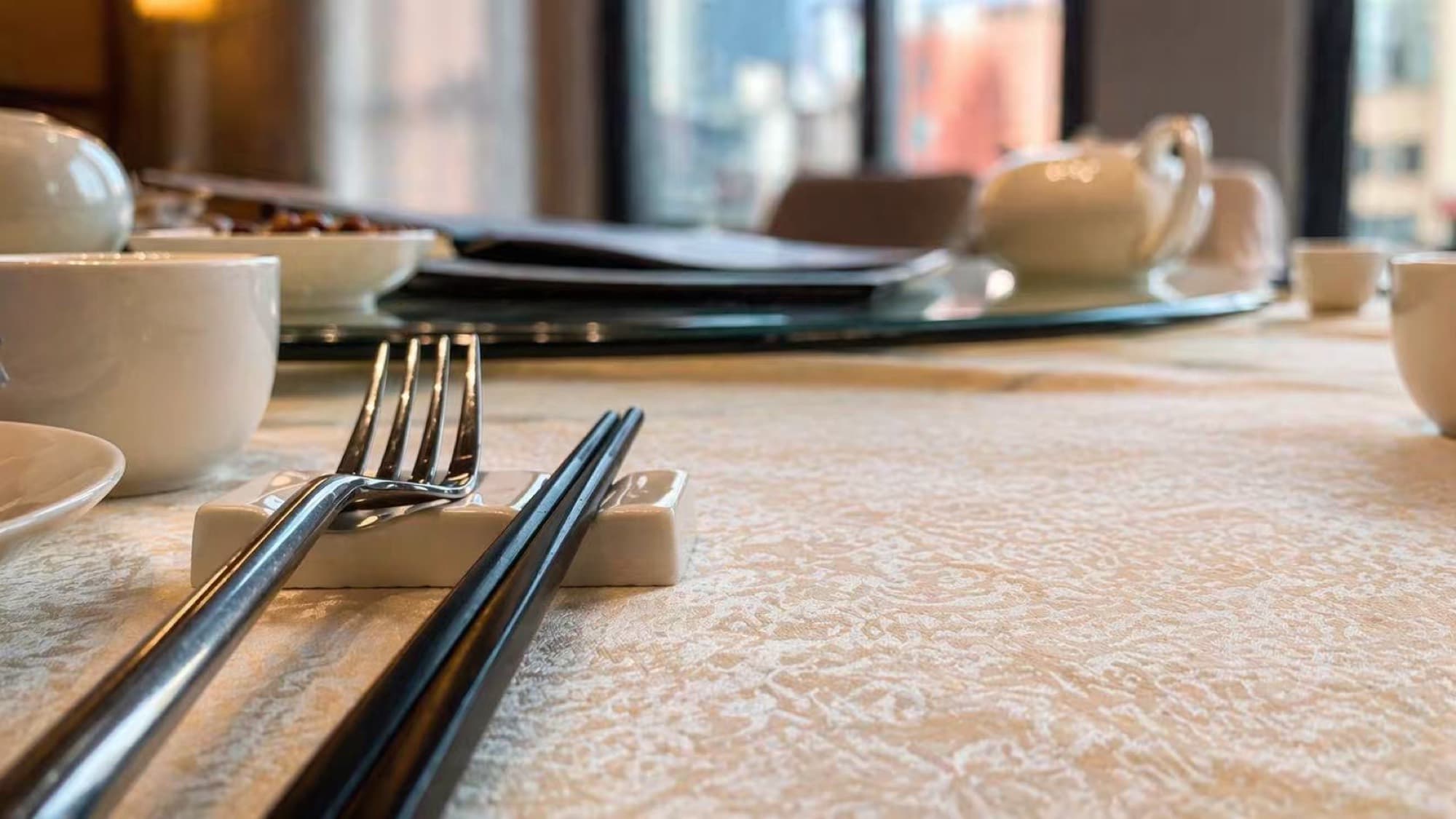 An elegant banquet place setting with chopsticks and fine china