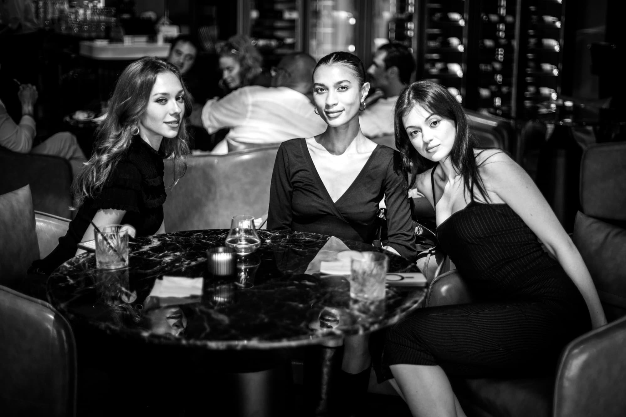Guests at a marble lounge table, in black and white