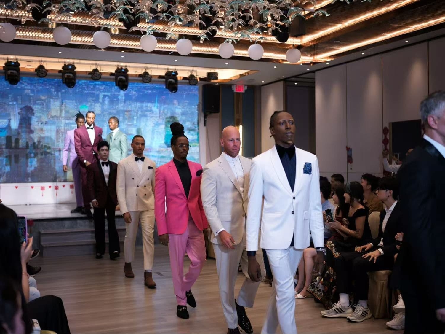 Models walking the runway in pastel and white suits