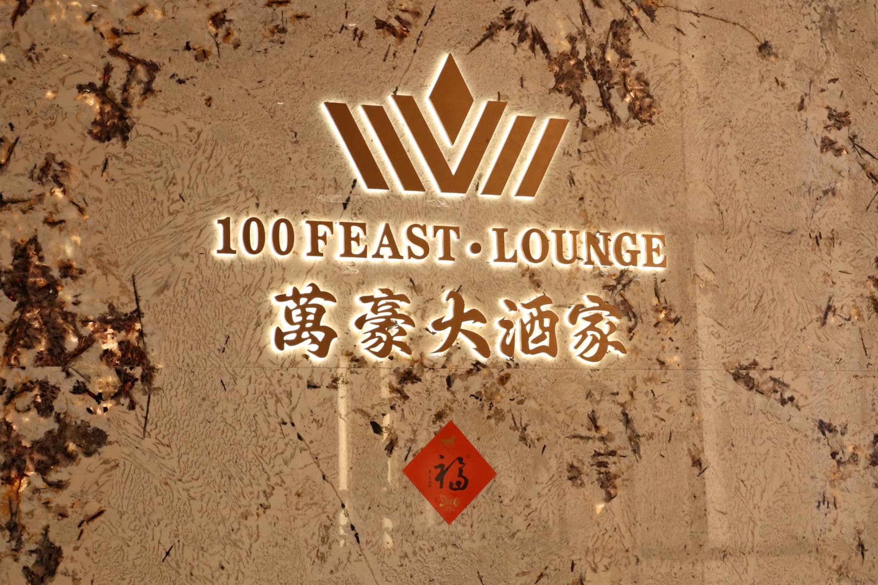 Backlit gold 100 Feast entrance logo