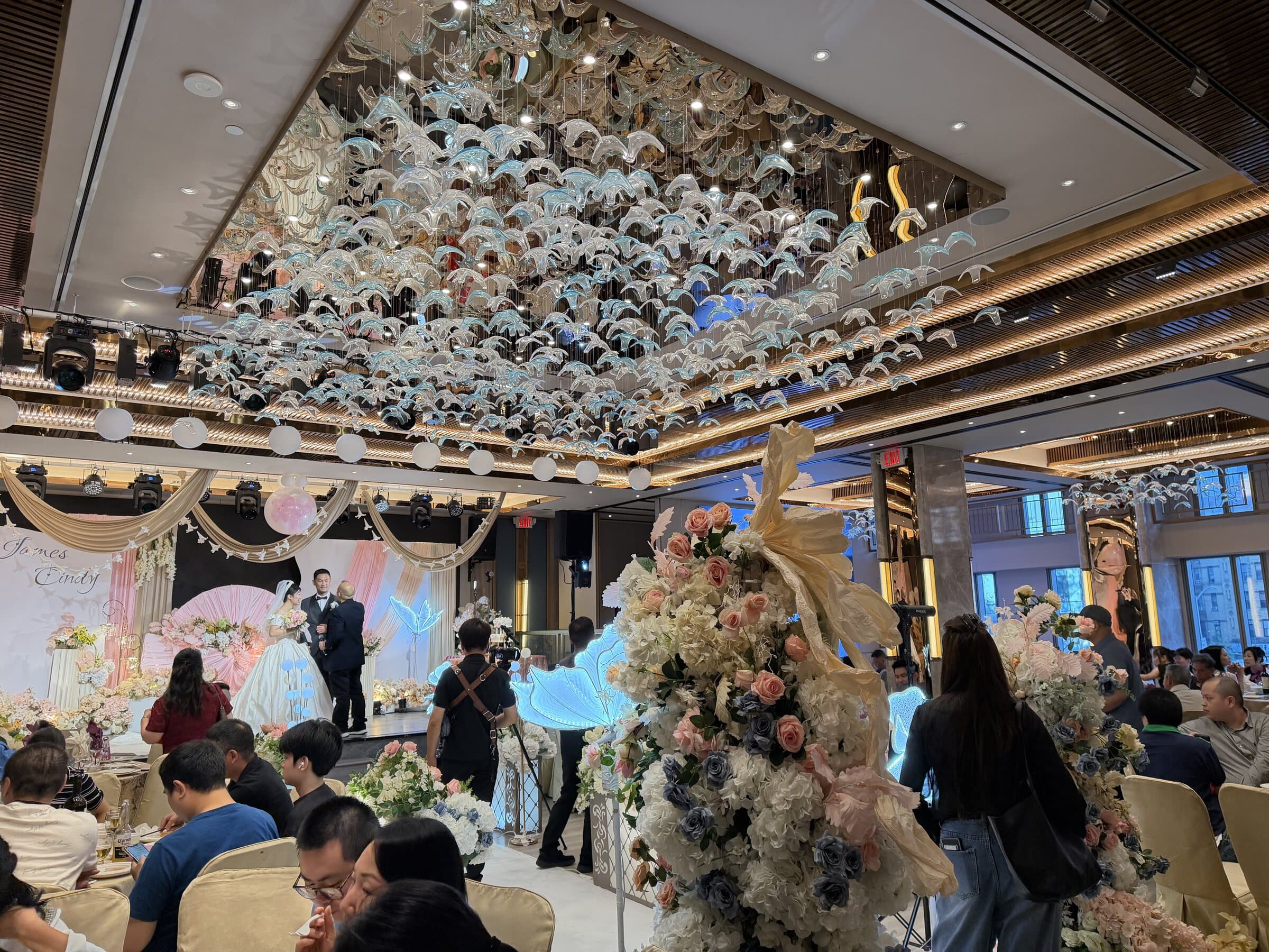 The glass-bird ceiling lit above a wedding banquet