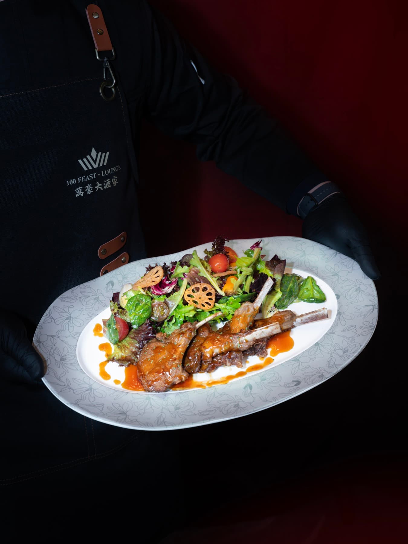 Server presenting honey-glazed lamb