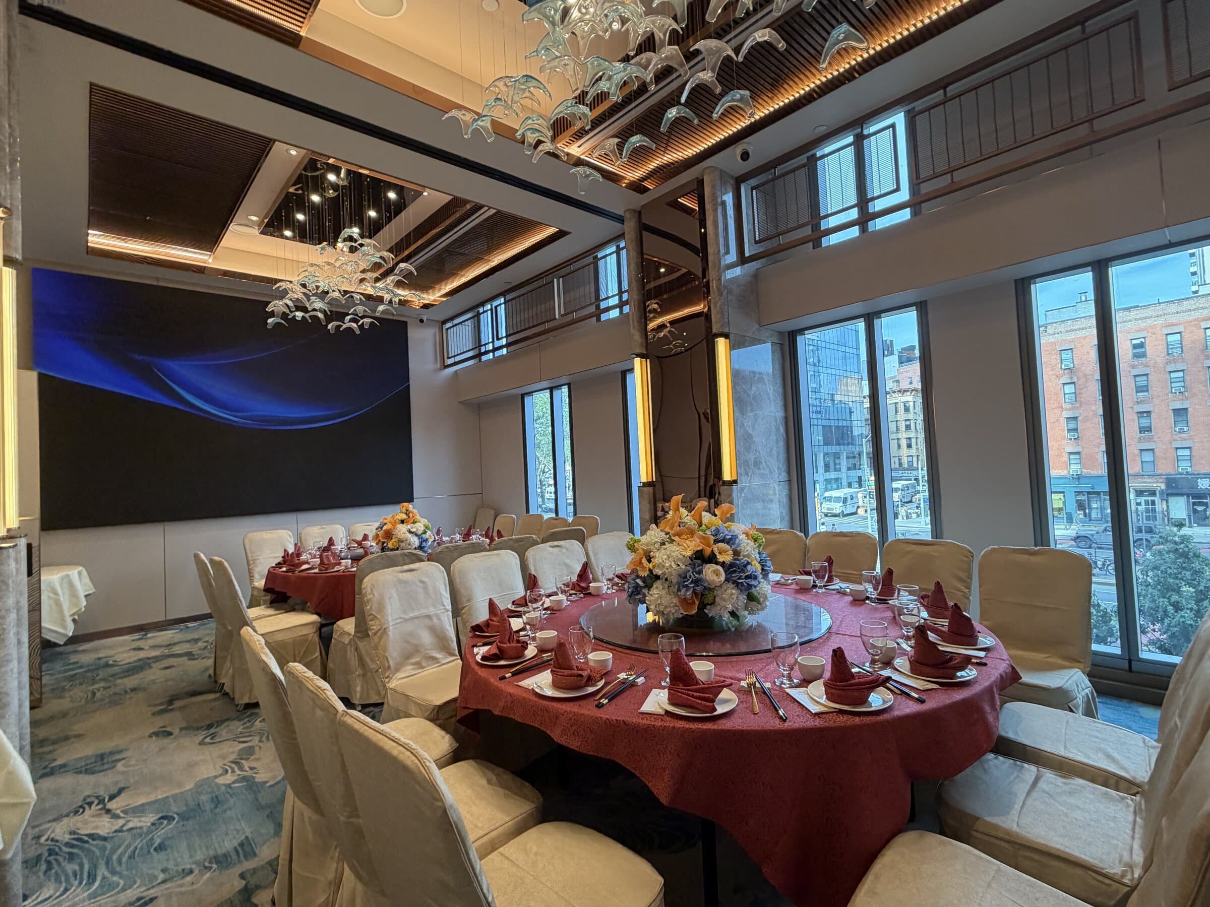 Double-height private room with a wave chandelier, LED wall and windows over the street