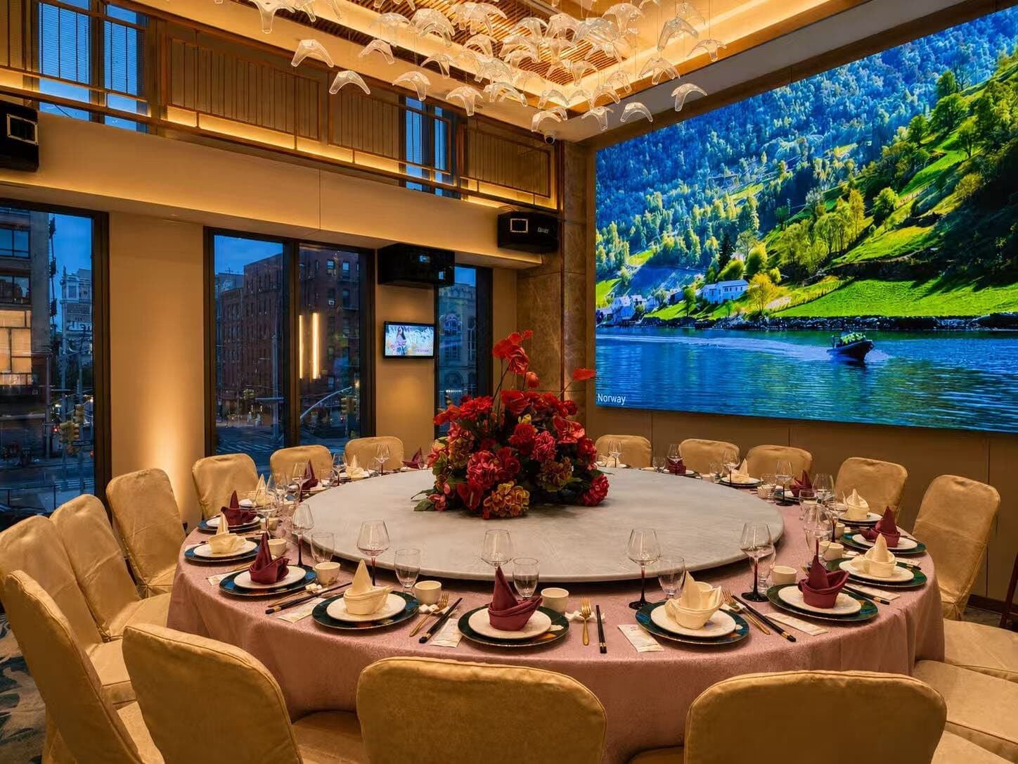 Private room laid with a rose-linen round table in front of a panoramic LED wall