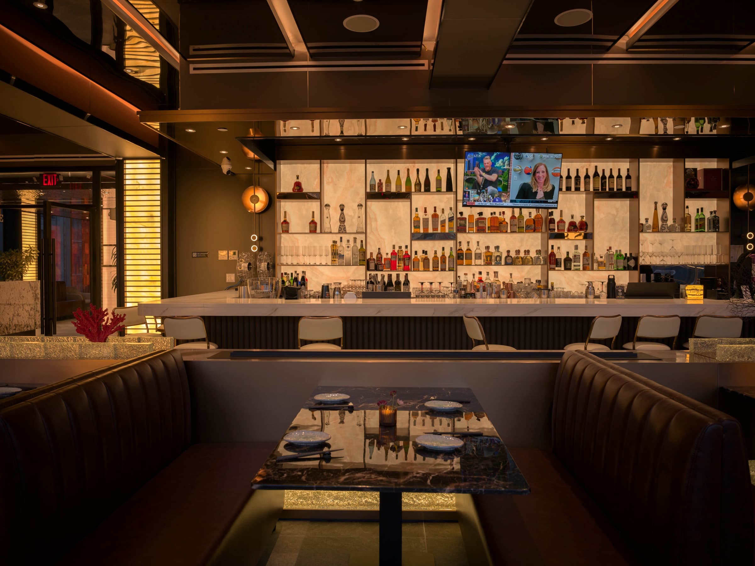 Bar and booth seating beneath backlit shelves