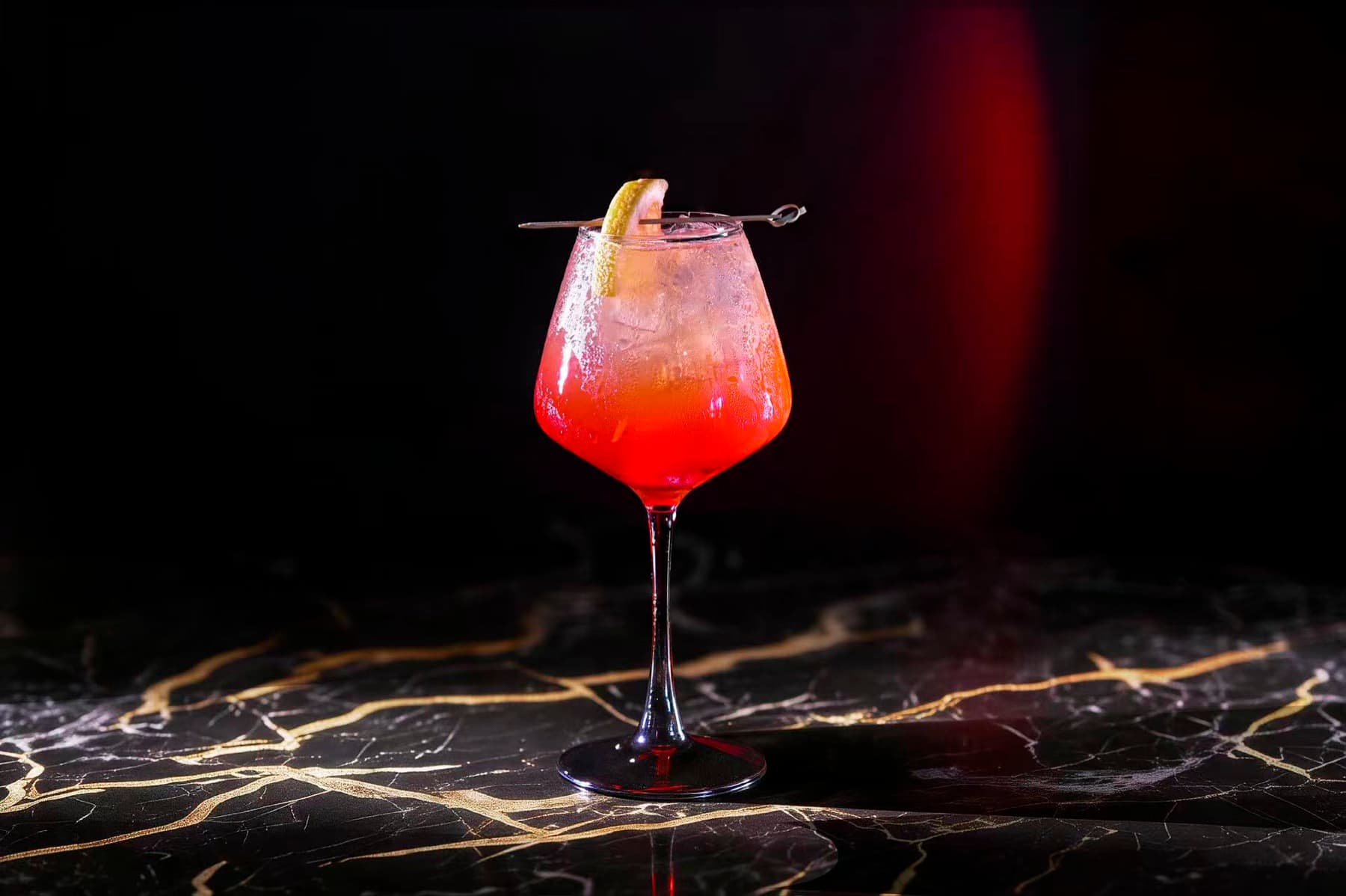 Crimson spritz on gold-veined marble