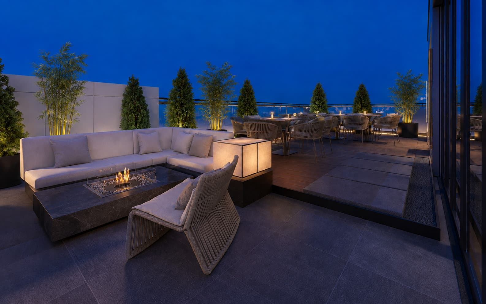 Terrace fire pit lit at blue hour, bamboo planting and the dining deck beyond